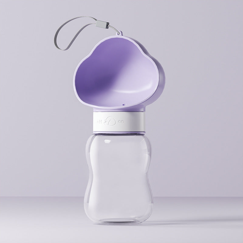 Portable pet water bottle and food container, in use with a pet
