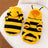 Small dog wearing a yellow and black striped bee sweatshirt