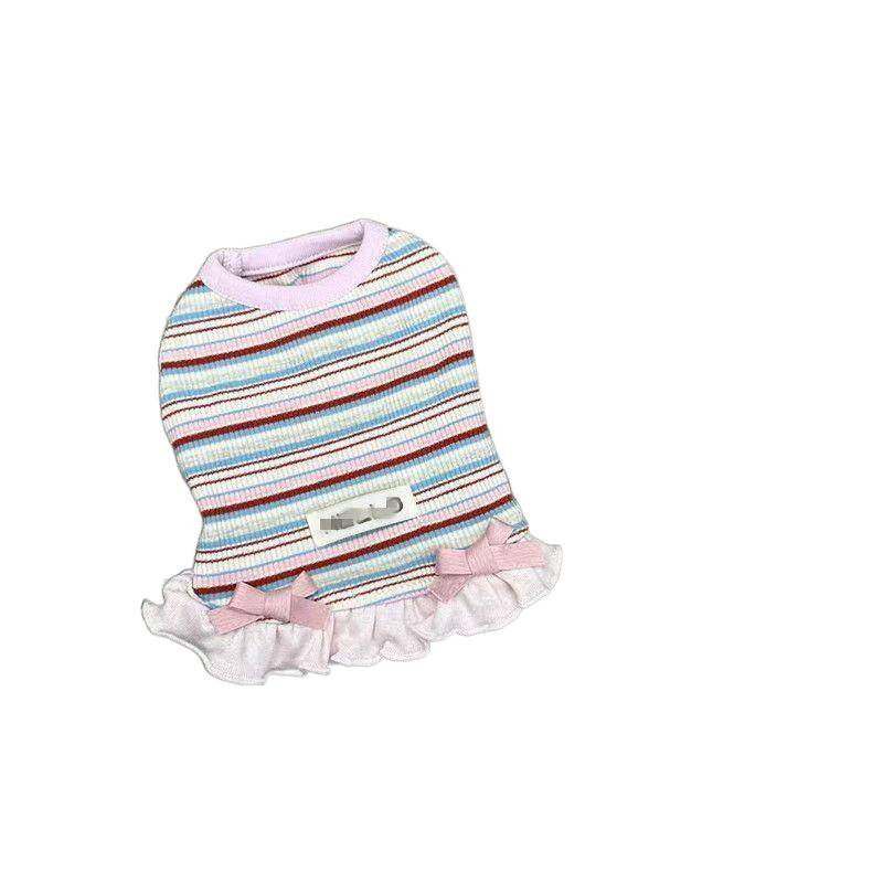 Small dog wearing a bright rainbow striped dress