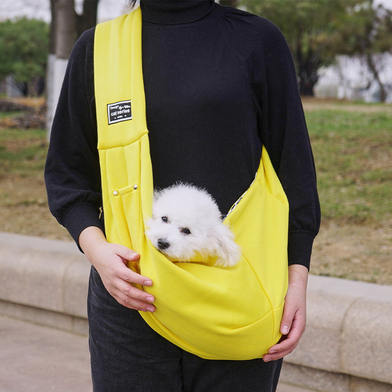 Grey pet sling shoulder bag carrying a small dog