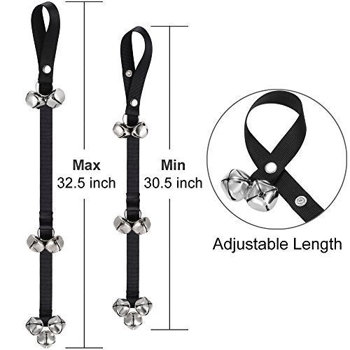 Puppy nudging stainless steel bells hanging on a door