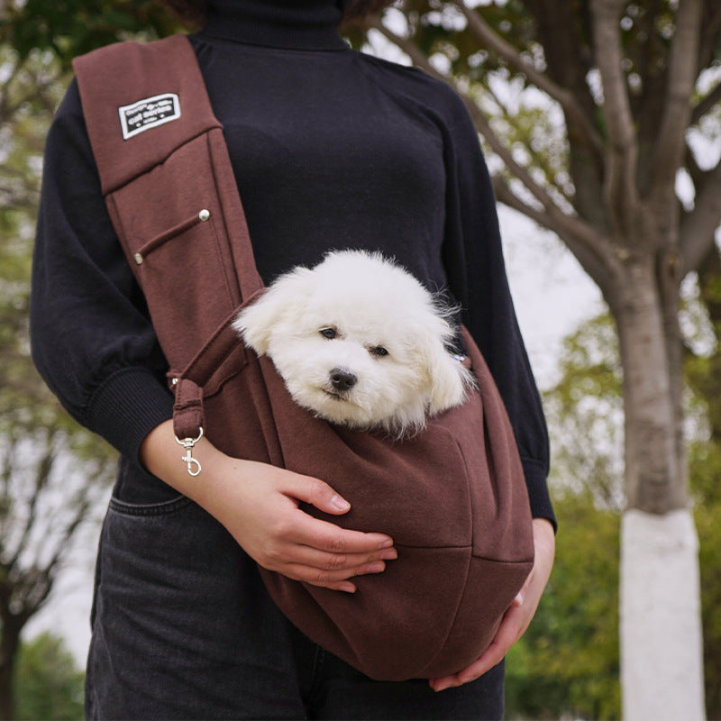 Grey pet sling shoulder bag carrying a small dog