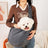 Grey pet sling shoulder bag carrying a small dog