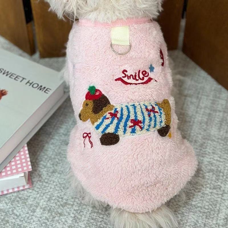 Small dog wearing a pink thick fleece cartoon vest