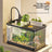 Small desktop plastic fish tank with clear cover and air pump, view 1