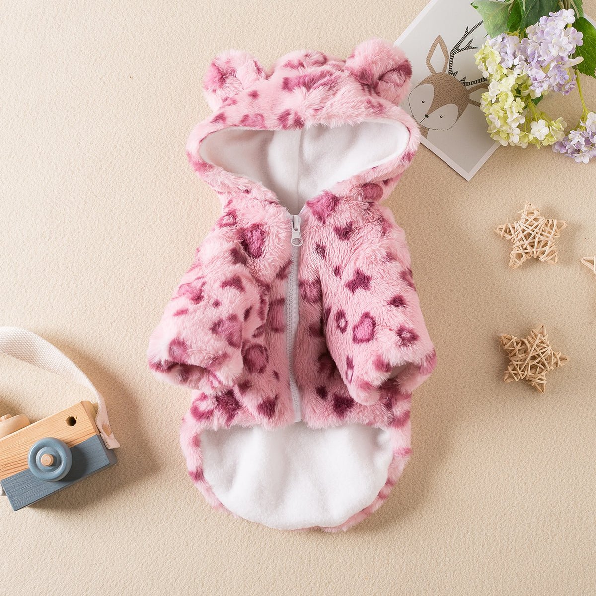 Small dog wearing a pink leopard print plush hoodie