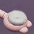 Light blue deshedding comb lifting fur from a cat