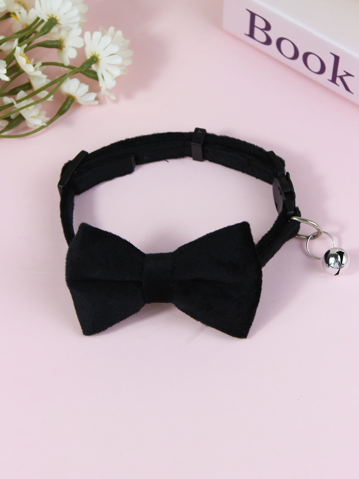 Striped cat collar with velvet bow, close-up detail view
