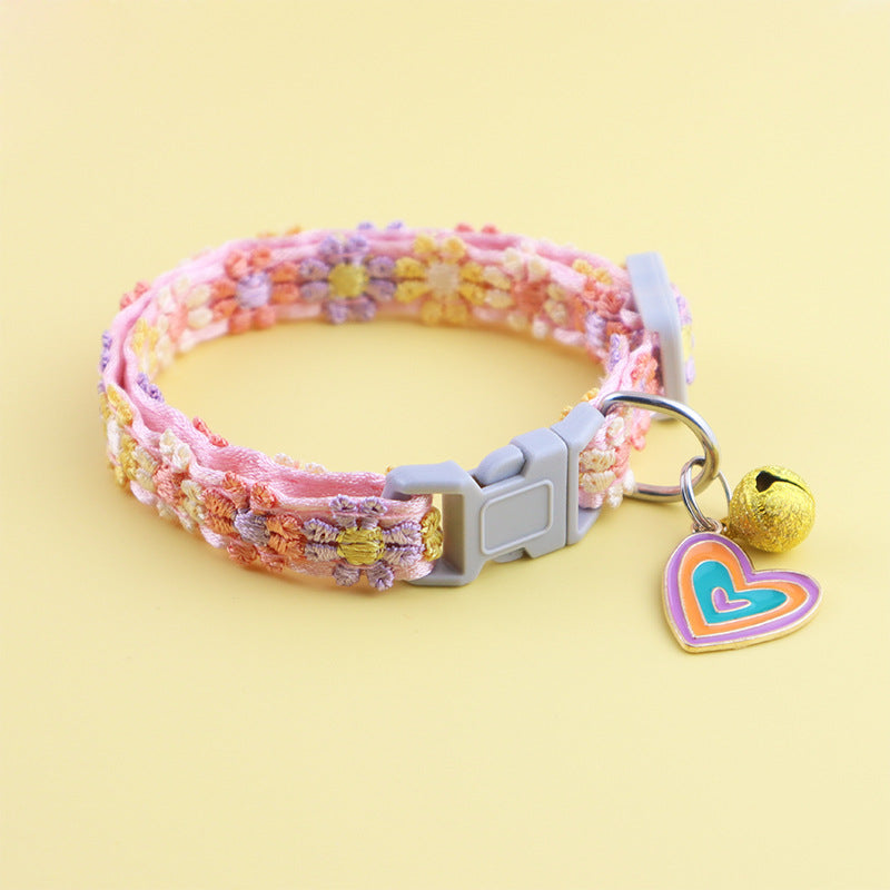 Blue and pink feather collar with bell on a cat