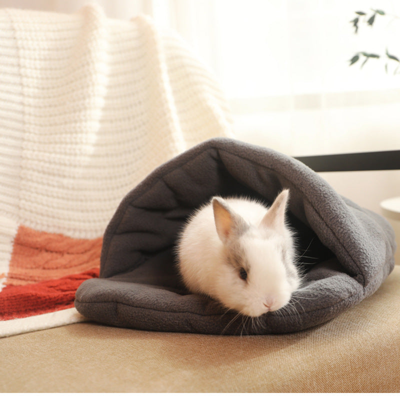 Guinea pig resting in a light grey warm nest