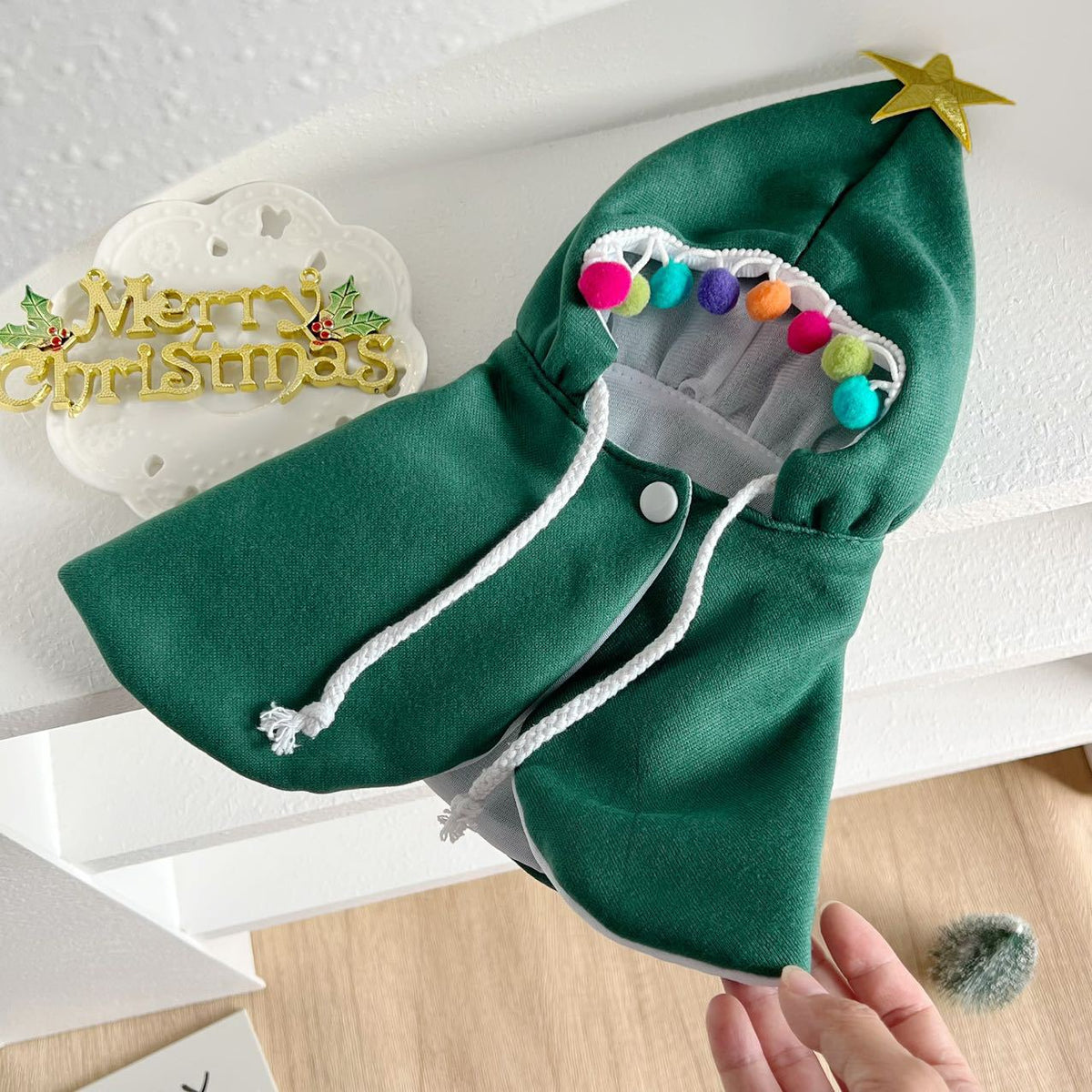Cat wearing a green Christmas tree costume cloak