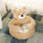 Cat curled up in a brown padded pet nest