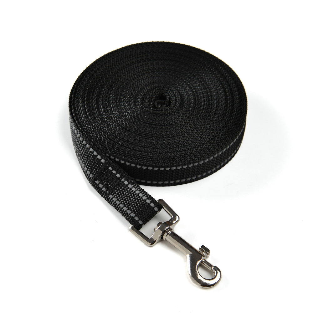 Reflective dog training line in red coiled on grass