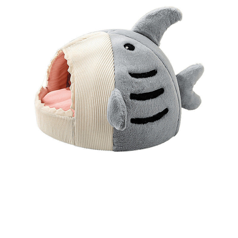 Cat peeking out of a light blue shark cave bed