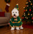 Small dog wearing a green Christmas cartoon cape outdoors