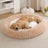 Small dog curled up in a khaki striped faux fur bed