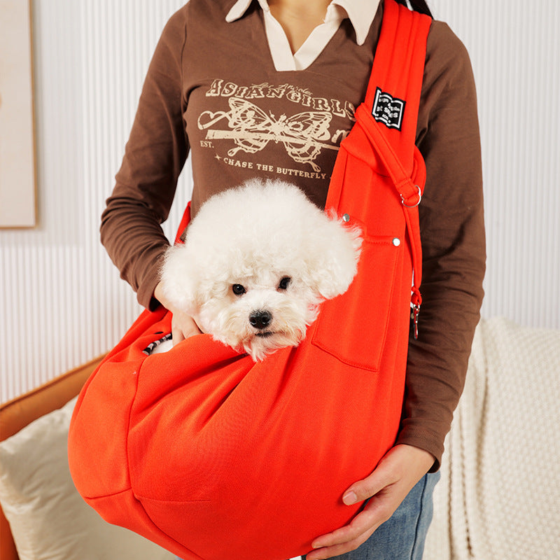 Grey pet sling shoulder bag carrying a small dog