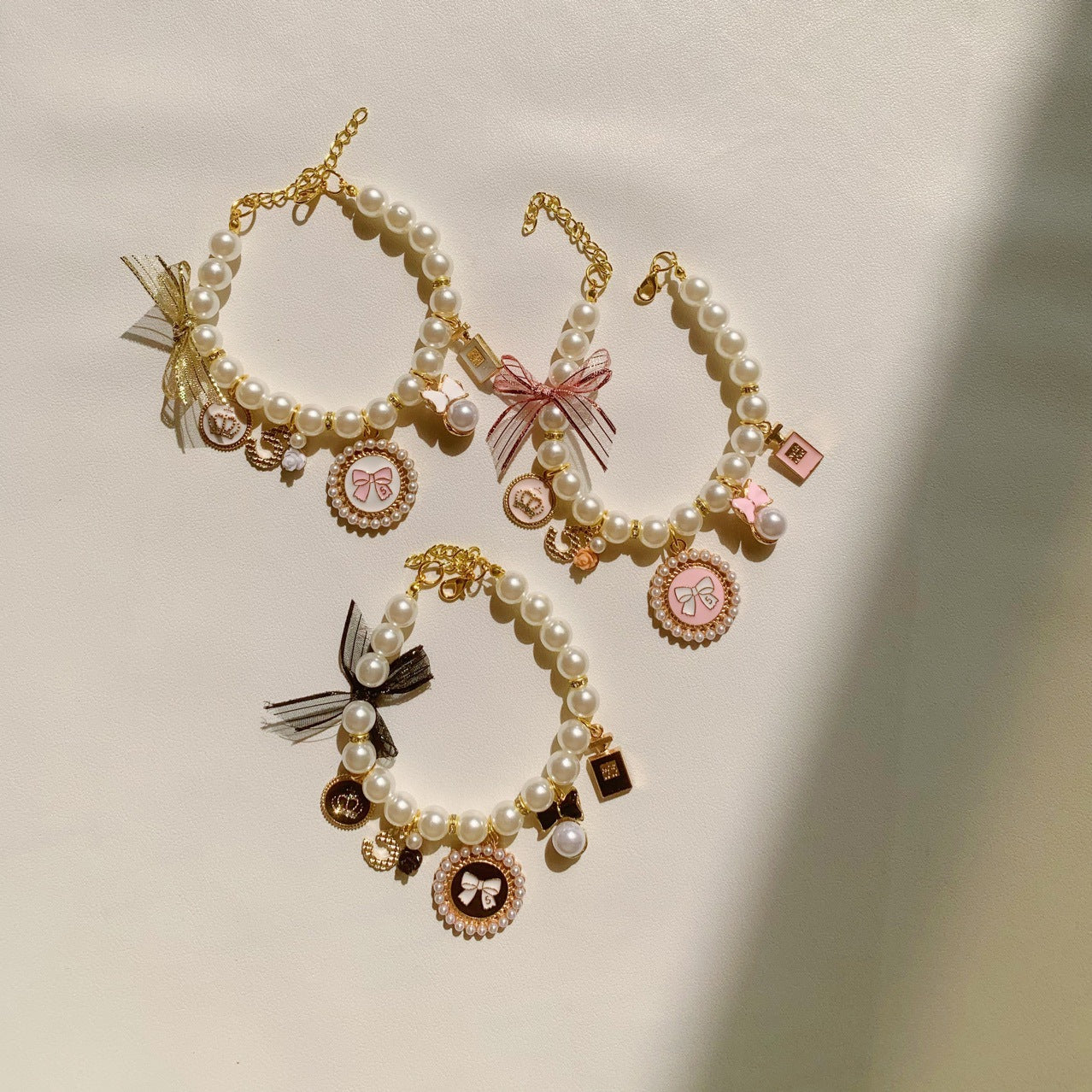 Faux pearl necklace collar with bell in Pink, front view