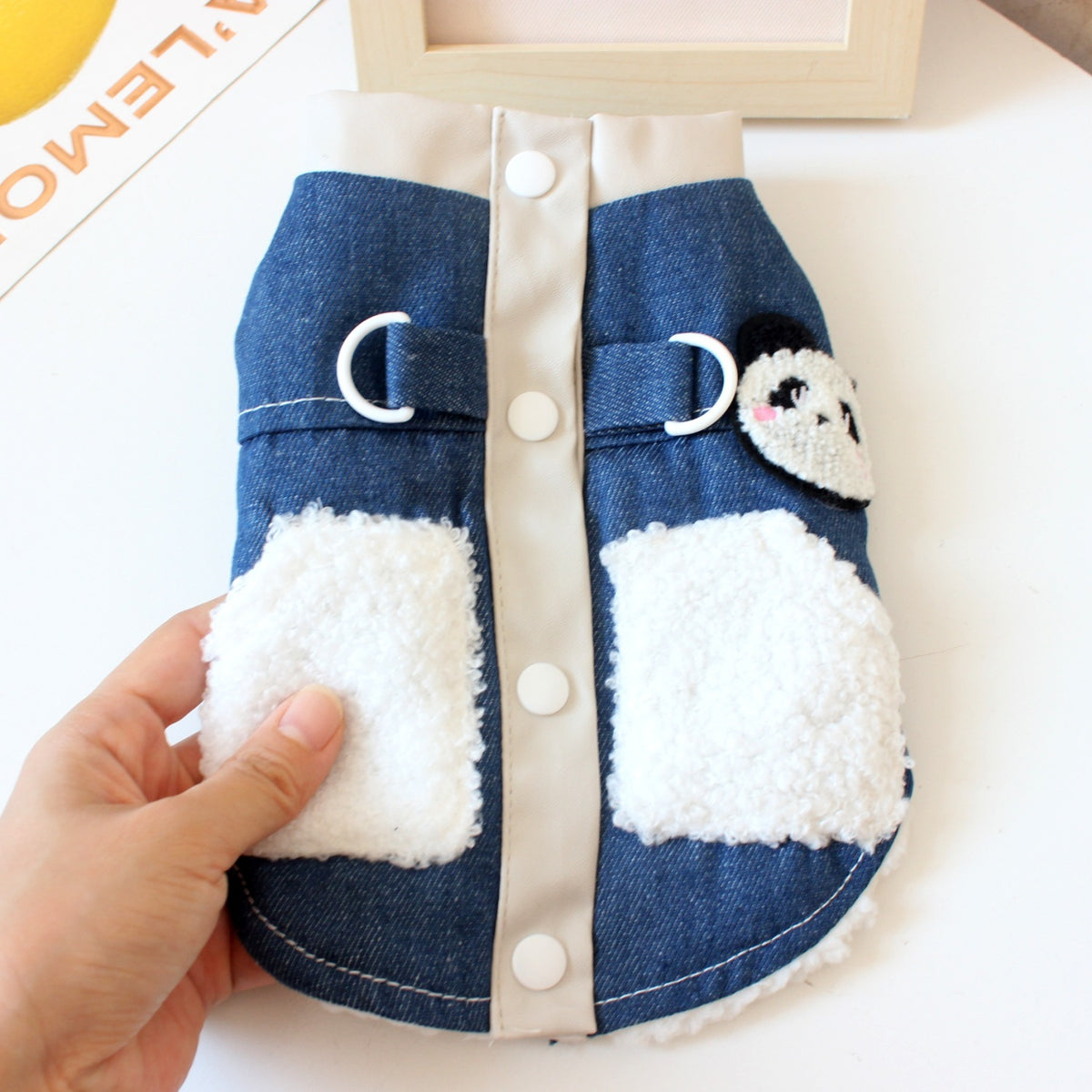 Fleece lined denim pet jacket with panda design, in use with a pet