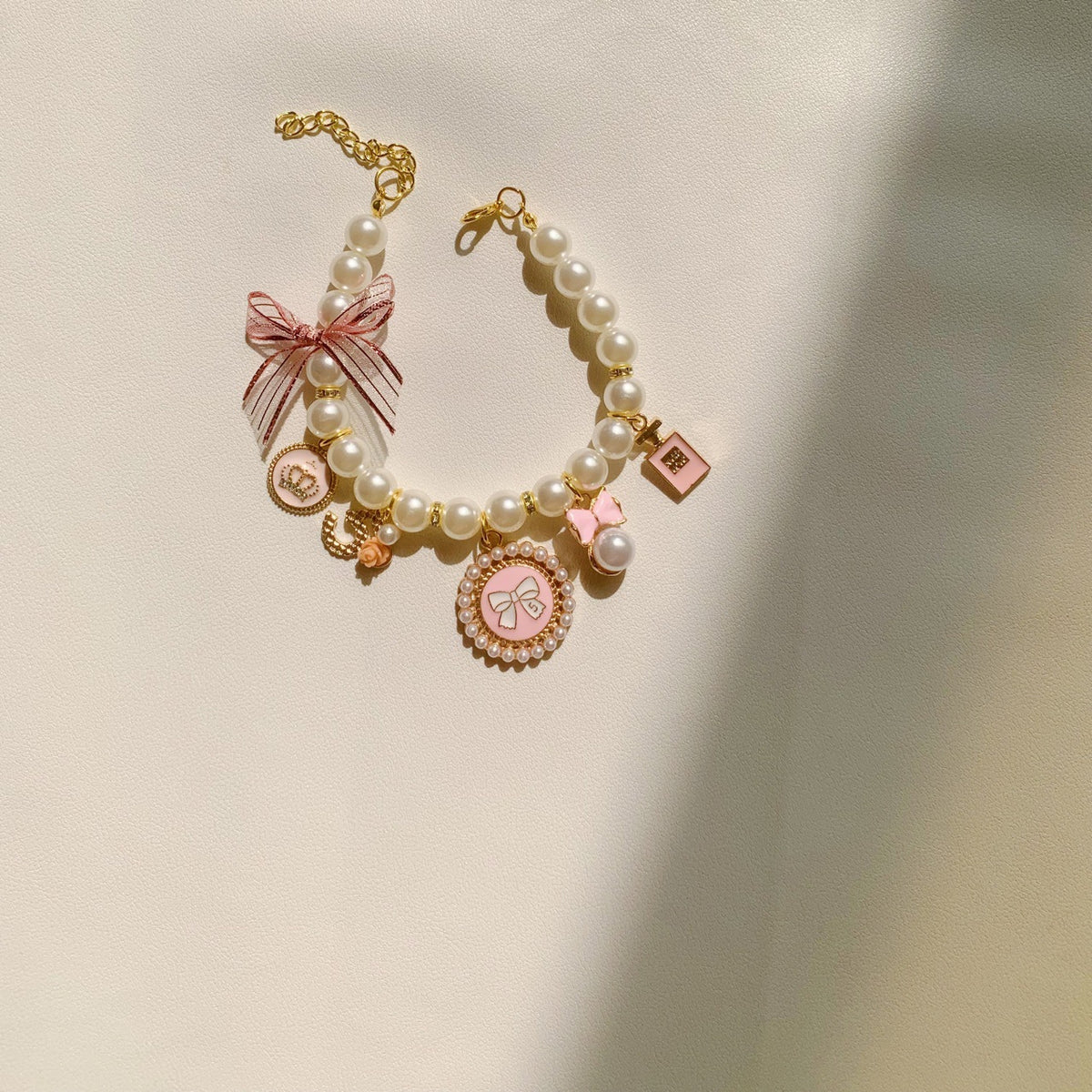 Faux pearl necklace collar with bell in Pink, in use with a pet