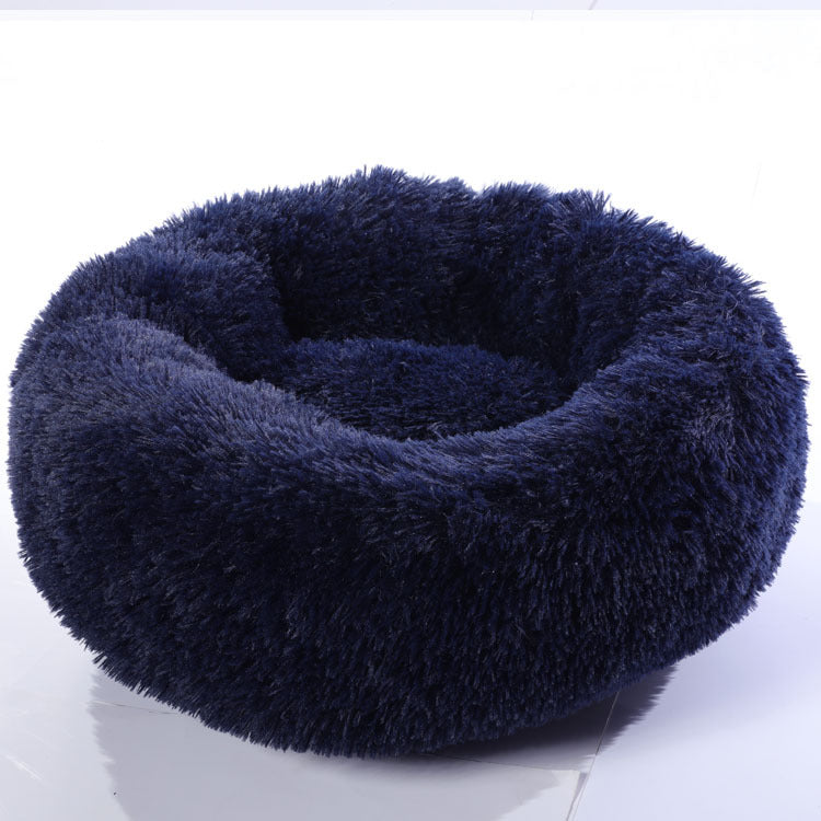 Dog sleeping in a cosy navy round bed