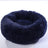 Dog sleeping in a cosy navy round bed