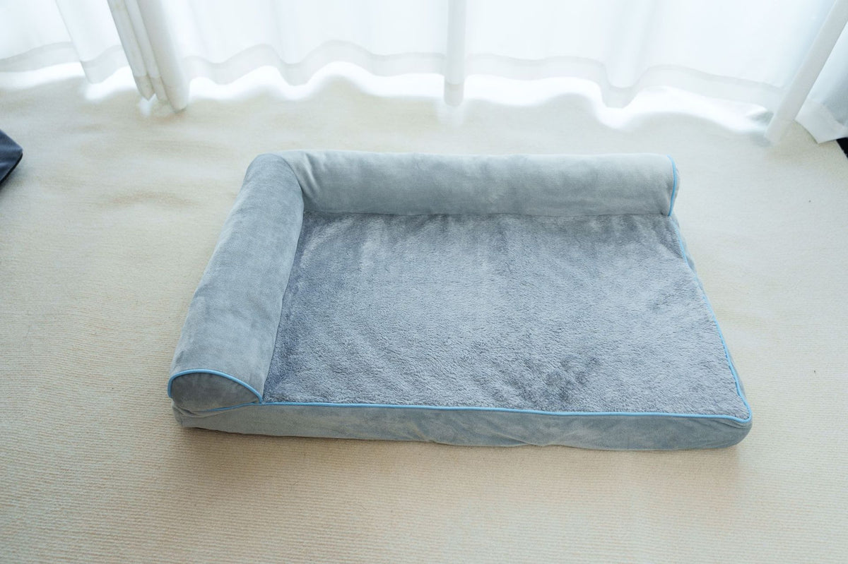 Dog resting on a dark grey plush pet bed