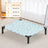 Small dog resting on an elevated bed with cyan alpaca pattern