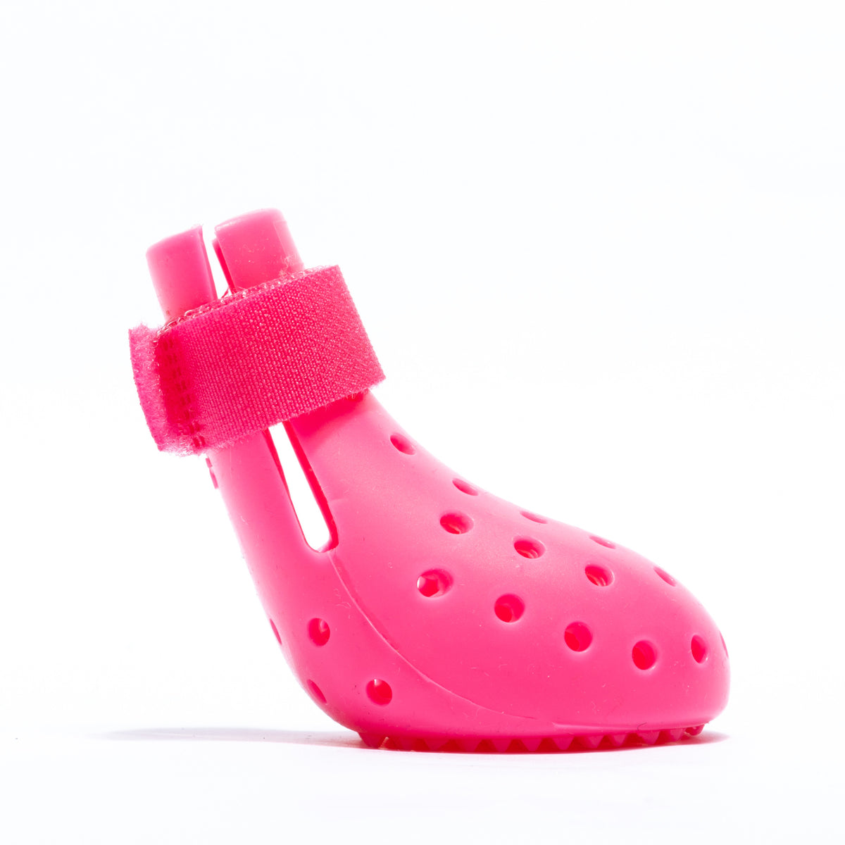 Small dog wearing bright silicone rain boots on a wet pavement