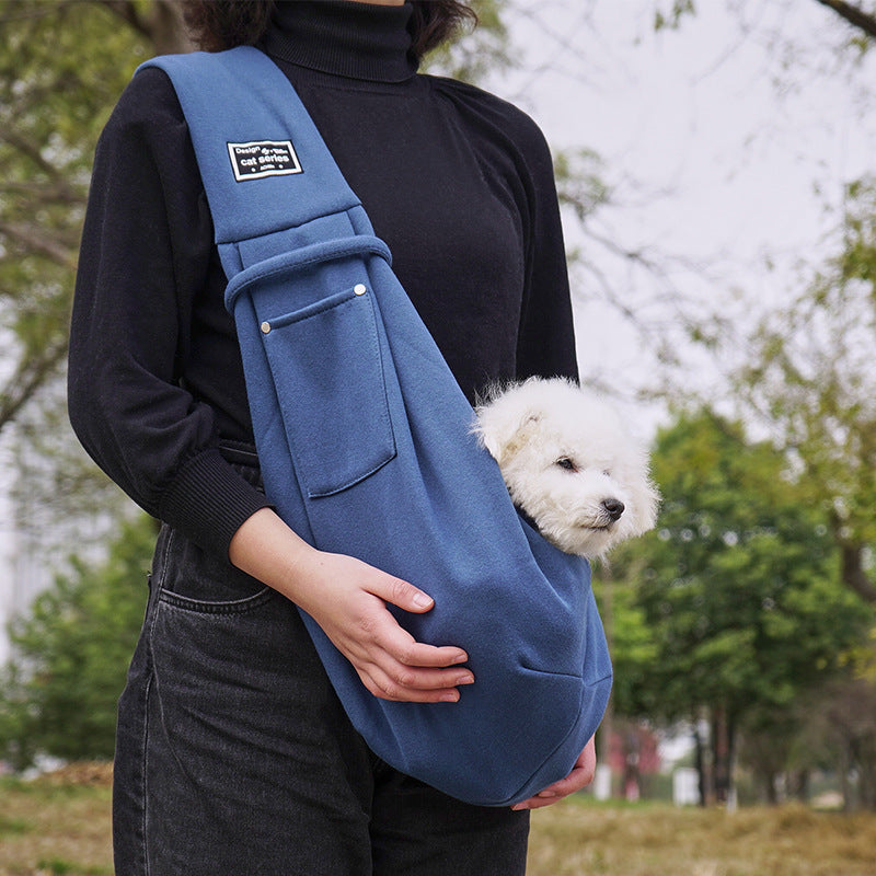 Grey pet sling shoulder bag carrying a small dog