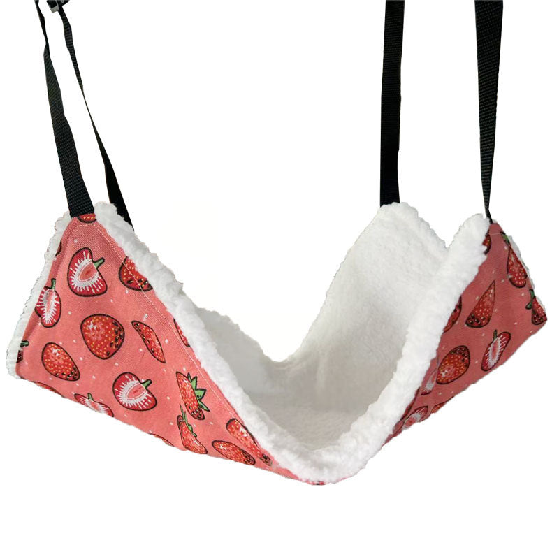 Cat lounging in a strawberry pattern cage hammock