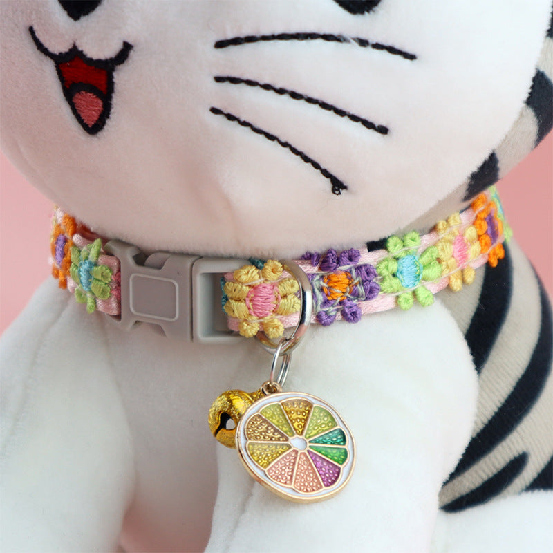 Blue and pink feather collar with bell on a cat