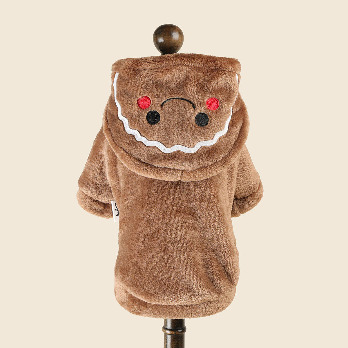 Small dog dressed in a plush gingerbread man costume