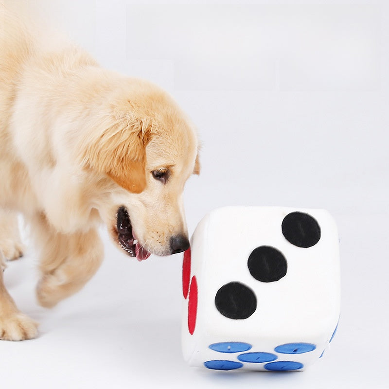 Golden retriever sniffing a white plush snuffle dice toy with blue dots