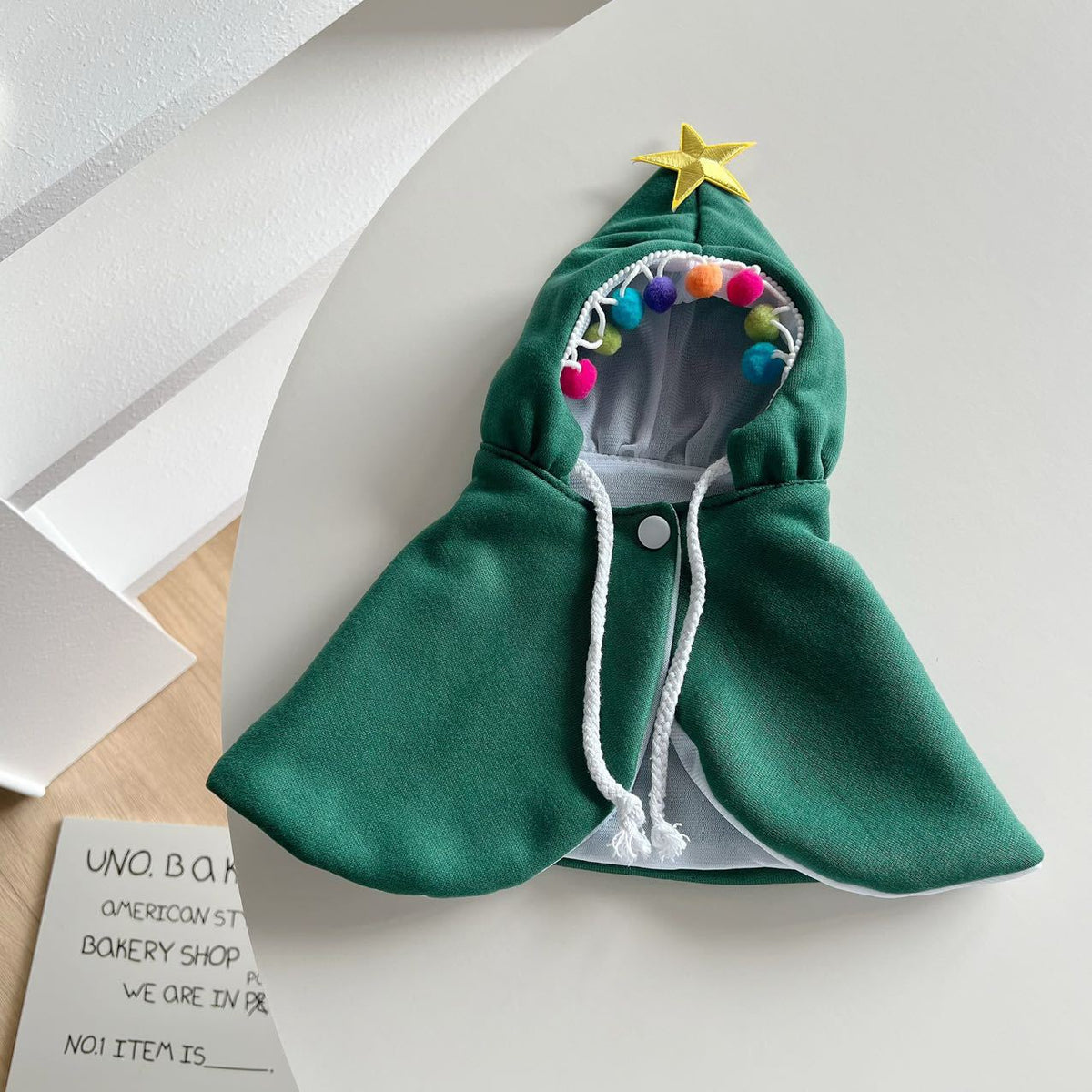 Cat wearing a green Christmas tree costume cloak