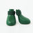 Small dog wearing bright silicone rain boots on a wet pavement