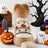 Small dog wearing a Halloween pumpkin and bat knit jumper