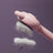 Light blue deshedding comb lifting fur from a cat
