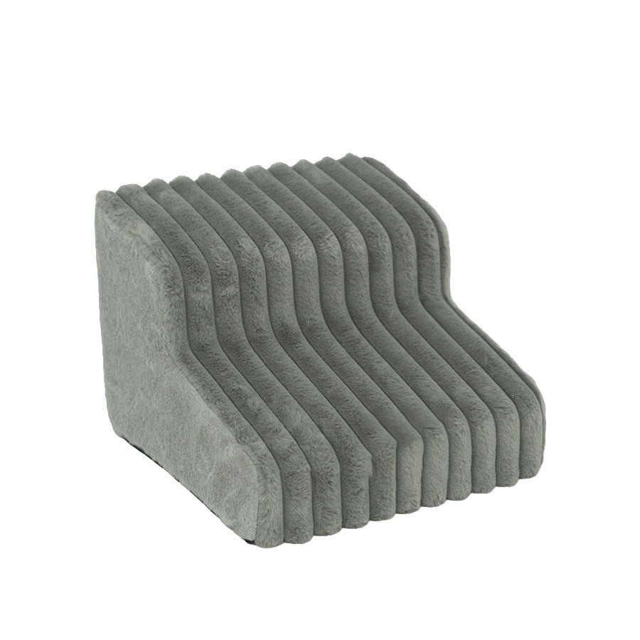 Grey two-step pet stairs placed beside a sofa