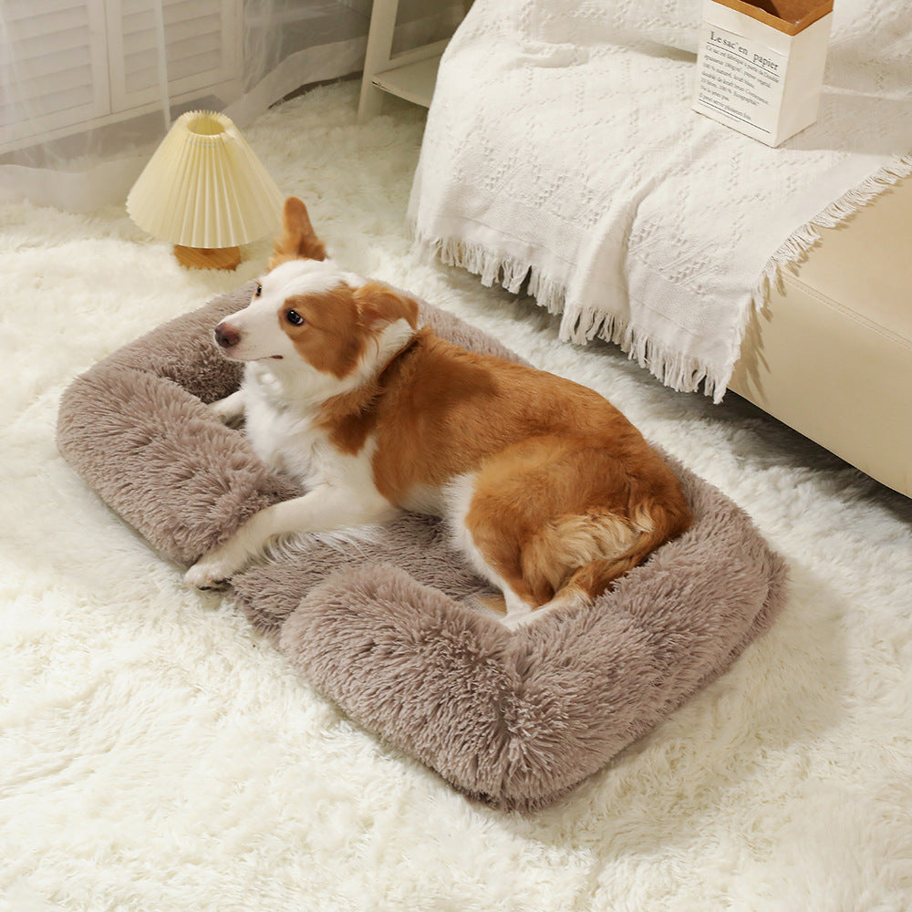 Dog sleeping in a pink square plush bed with cushion