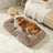 Dog sleeping in a pink square plush bed with cushion