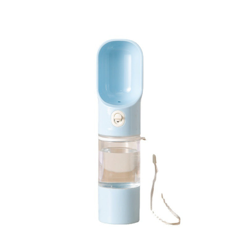Dog drinking from a blue travel water bottle on a walk