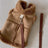 Small dog wearing a brown suede effect vest