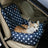 Small dog travelling in a grey plaid car seat bed