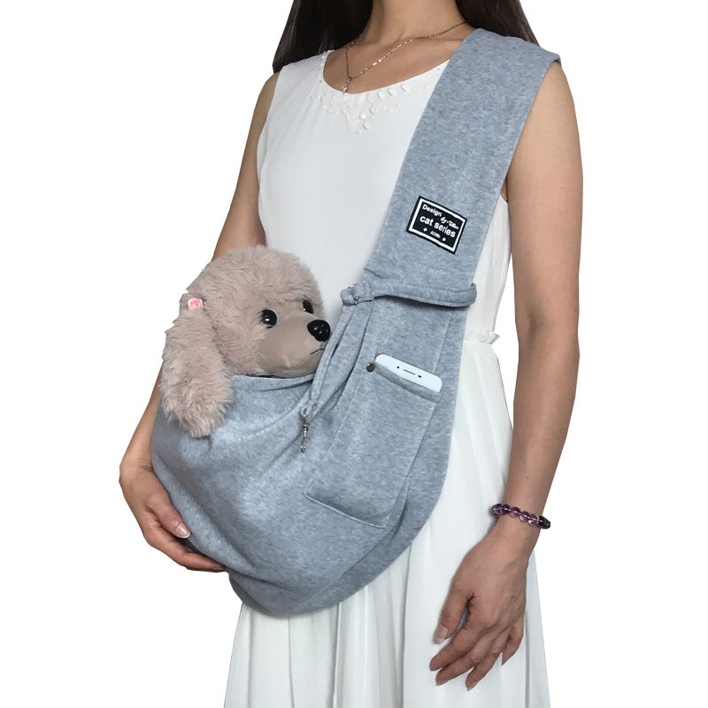 Grey pet sling shoulder bag carrying a small dog