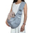 Grey pet sling shoulder bag carrying a small dog
