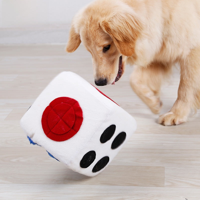 Dog pawing a soft white fleece dice puzzle toy with red dots