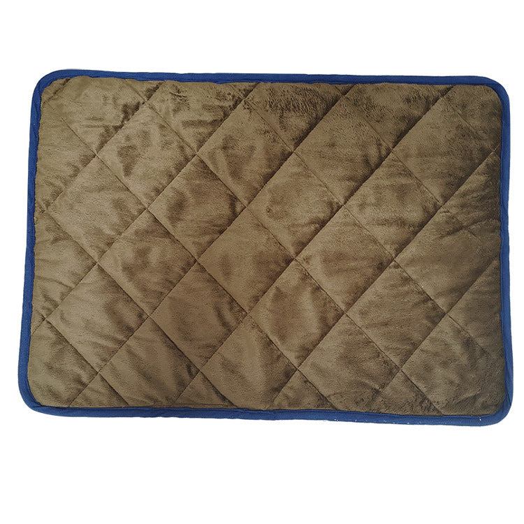 Dog lying on a navy self-warming pad in winter