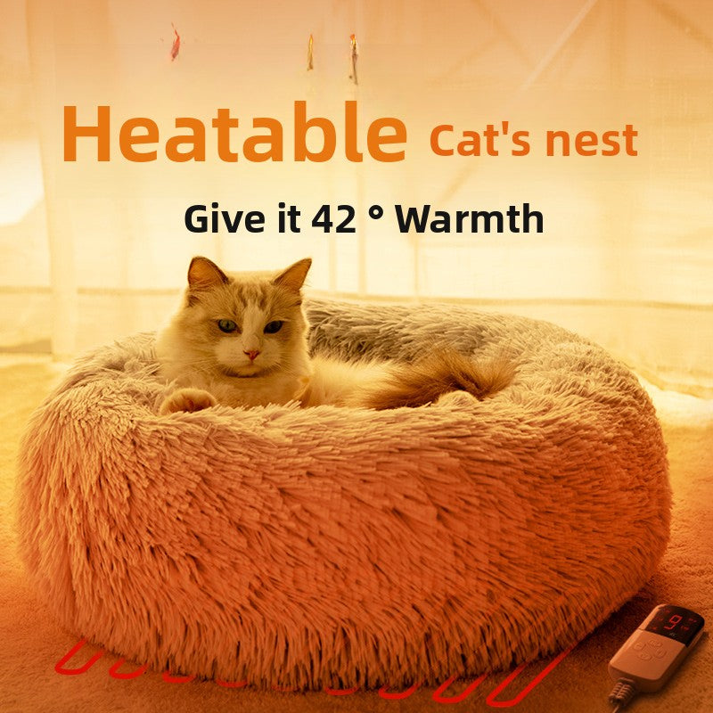 Cat sleeping in a round electric warming bed in winter