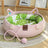 Cat lying in a woven rattan nest with green pad